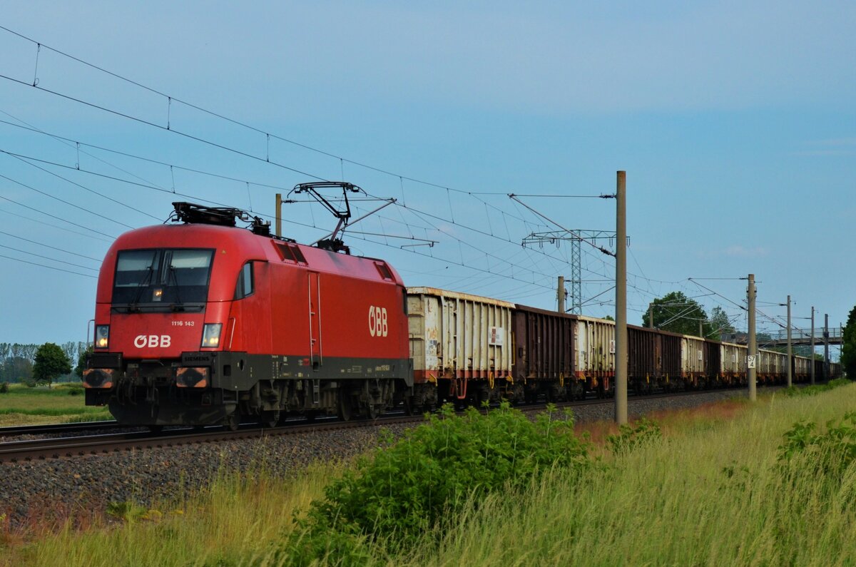 ÖBB 1116 143 fährt zusammen mit einem Güterzug, Richtung Hamburg, am 01.06.2021 im Gegengleis duch Vietznitz.