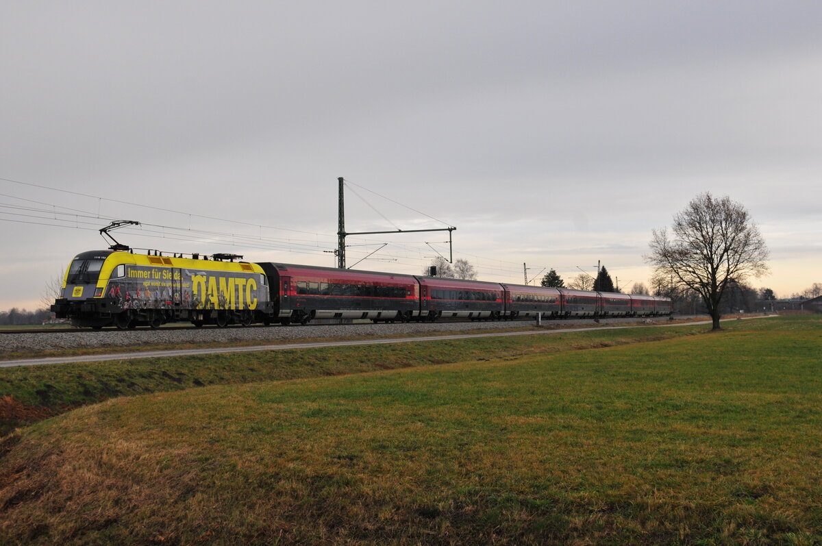 ÖBB 1116 153 in ÖAMTC-Beklebung vor einem Railjet auf der Strecke Salzburg in Richtung München kurz nach Übersee am Chiemsee. Aufgenommen am 12.12.20 