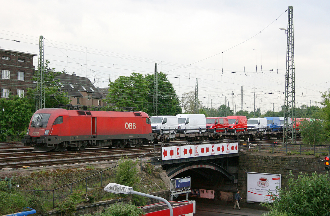 ÖBB 1116 155 mit werksneuen Nutzfahrzeugen im Güterbahnhof Köln-Kalk Nord.
Fotografiert vom S-Bahn-Bahnsteig des Bahnhofs Köln-Mülheim.
Aufnahmedatum: 18. Mai 2012
