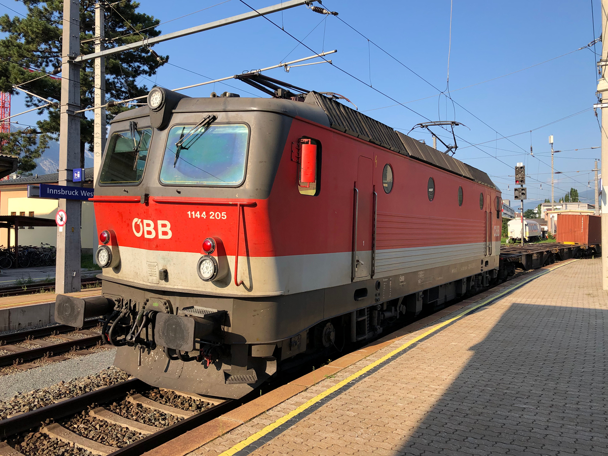 ÖBB 1144 205 mit einem Containerzug Richtung Wolfurt. Hier bei der Durchfahrt durch den Innsbrucker Westbahnhof am Abend des 23.07.2021