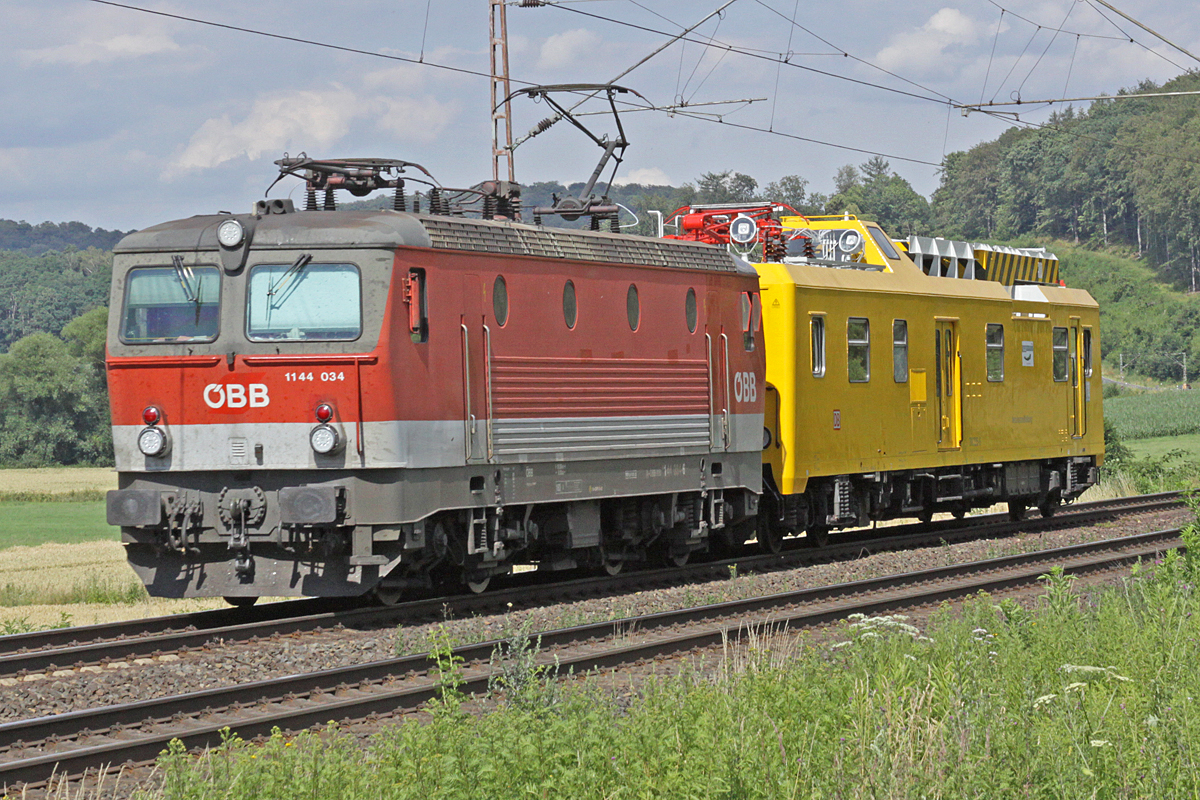 ÖBB 1144 u. Messwagen der DB Netz am 12.07.2016  16:32 nördlich von Salzderhelden am BÜ 75,1 in Richtung Göttingen