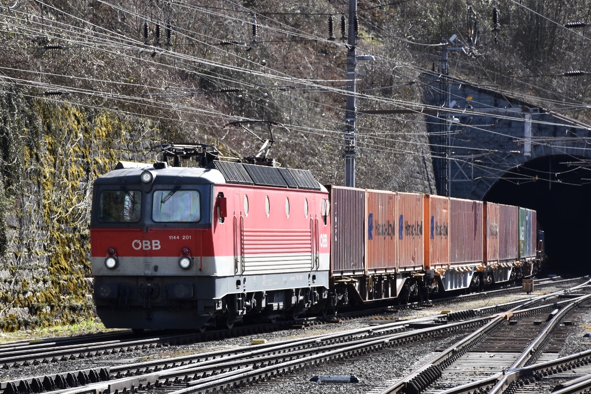 ÖBB 1144.201 hat am 30.03.2018 mit einem gemischten Güterzug den Schattenburgtunnel verlassen und fährt in den Bahnhof Feldkirch ein.