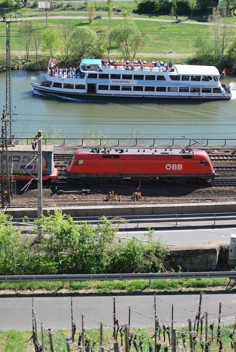 ÖBB-Taurus-Lok mit Containerzug kreuzt ein Schiff den Main entlang. 19. April 2019