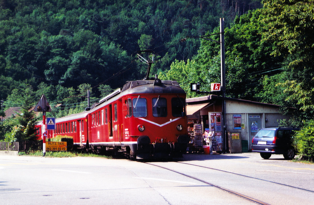 Oensingen Balsthal Bahn/OeBB.
Der ehemalige RM Pendelzug bestehend aus dem Hochleistungstriebwagen BDe 4/4ll 576 250 mit B 551 und ABt 991 hat die OeBB im Jahre 2004 übernommen und feierlich mit der neuen OeBB-Anschtift dem Betrieb übergeben. Bereits aber im Jahre 2005 wurde diese fotogene Komposition an den Verein Pendelzug Mirage weiteregegeben und durch den ex SBB RBe 540 ersetzt. Der Abbruch erfolgte im 2007.
Beim Zwischenhalt auf der Station Thalbrücke im Frühling 2004.
Besondere Beachtung gilt dem alten Stationsgebäude sowie dem damals noch nicht durch Schranken gesicherten Bahnübergang.
Foto: Walter Ruetsch


