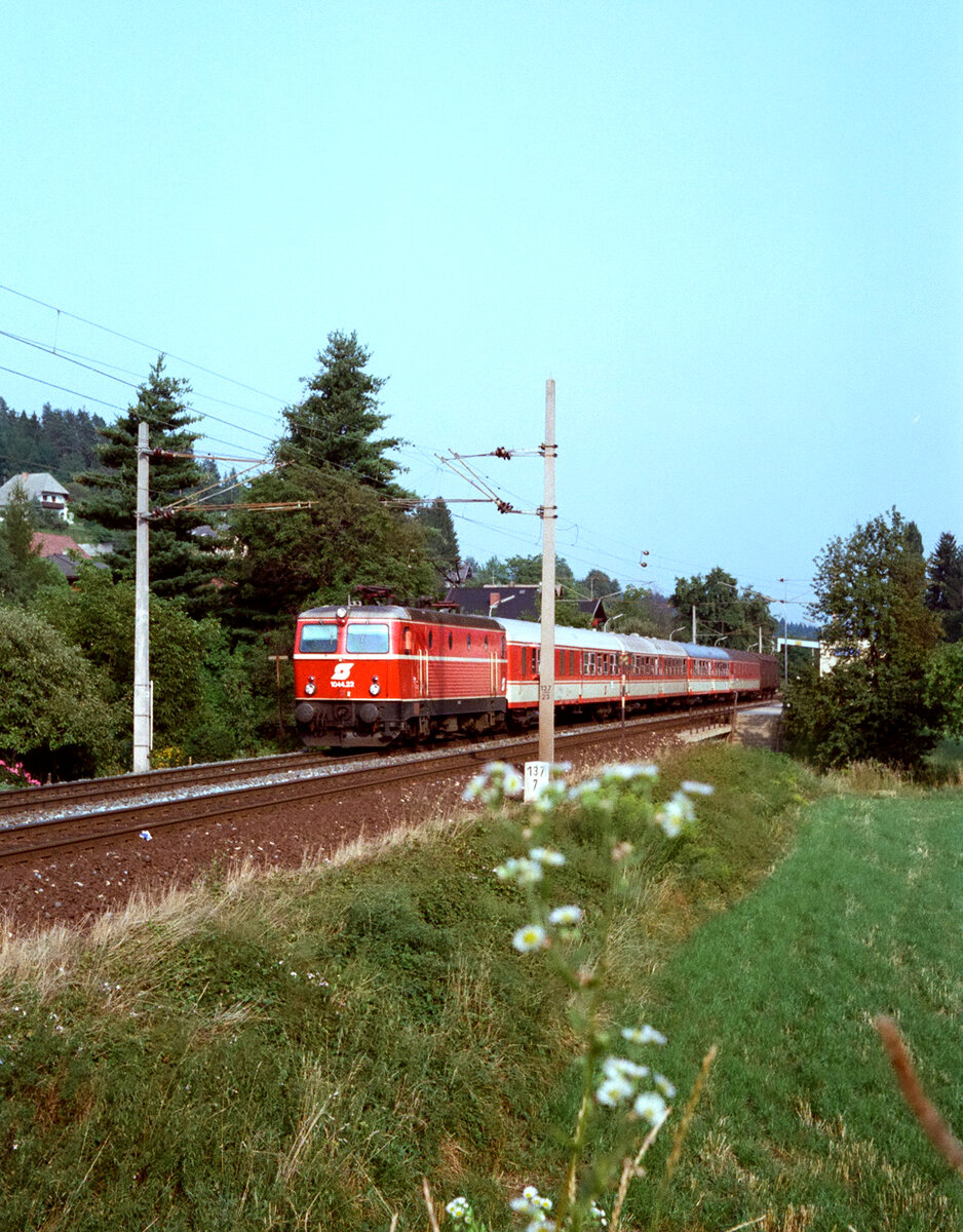 Österreichischer Personenzug mit ÖBB-Lokomotive 1044.22 unmittelbar nach der Station Pritschilz (am Wörthersee) im August 1983