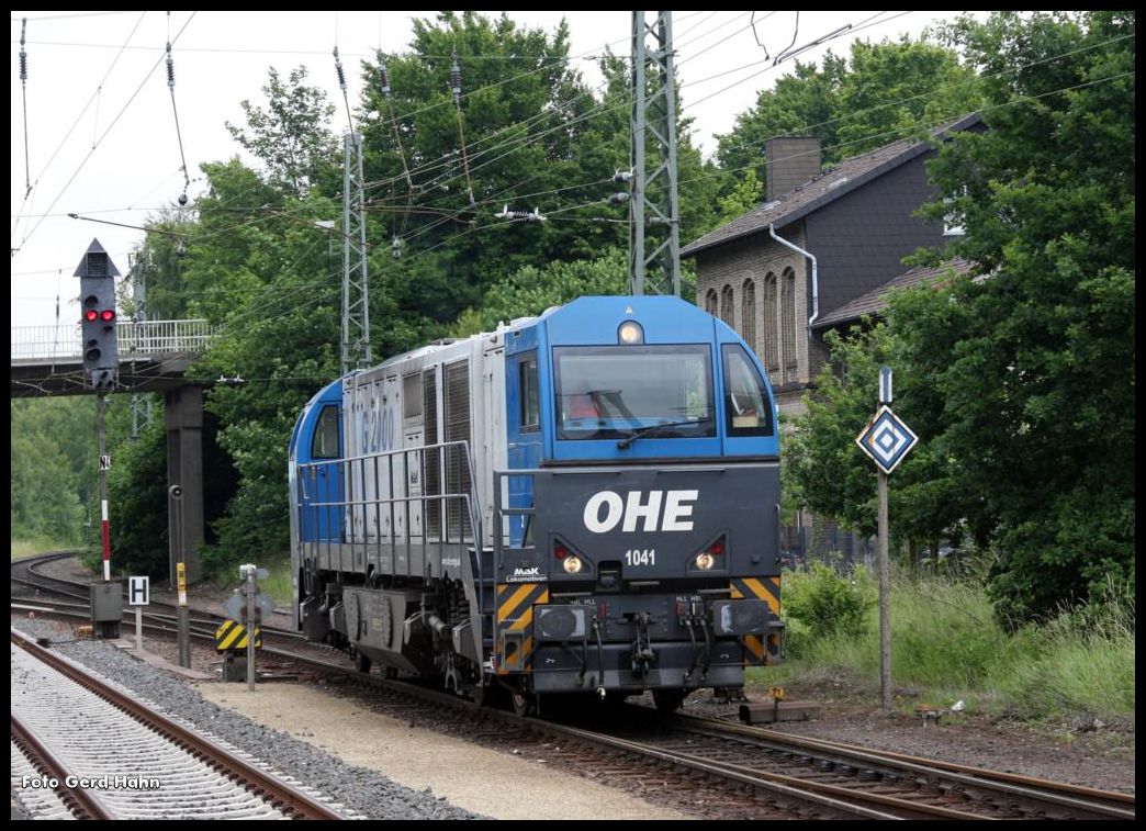 OHE 1041 G 2000 hat einen Leerwagenzug aus dem Stahlwerk Georgsmarienhütte gebracht und setzt hier gerade im Bahnhof Hasbergen am 24.6.2015 um. Rechts ist der alte ehemalige Personenbahnhof der Hüttenbahn in Hasbergen zu sehen!