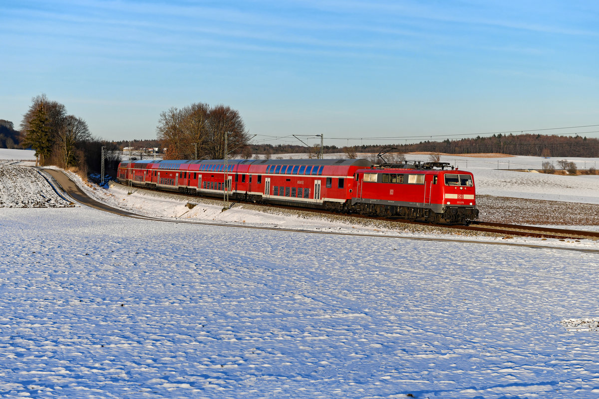 Ohne Kontrollziffer auf der Front ist 111 076 unterwegs. Hier ist sie am 14. Februar 2021 bei Kottgeisering mit dem RE 57426 auf der Fahrt von München HBF nach Memmingen zu sehen. 