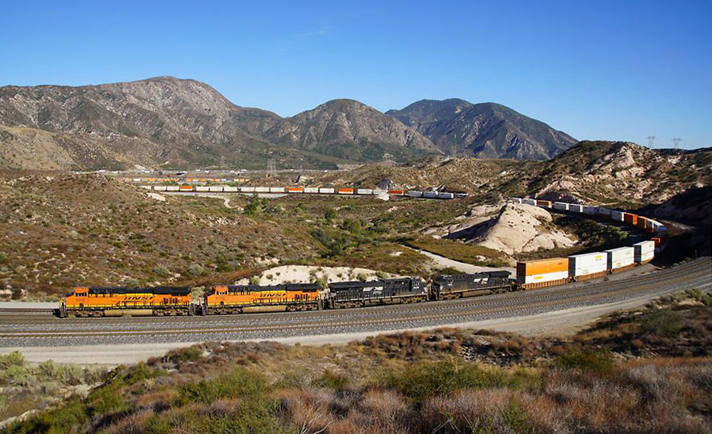 Panoramafoto der Sullivan's Curve: alle Containerwagen, die auf diesem Bild zu sehen sind, gehören zum gleichen Zug! Cajon Pass, CA, 22.9.2022