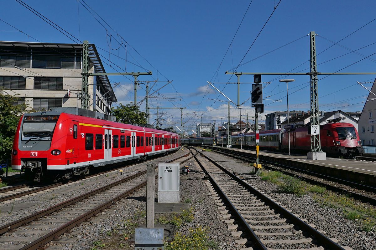 Paralleleinfahrt in den Bahnhof von Friedrichshafen - 425 807-5 auf Rangierfahrt und 1016 007 mit den Wagen des IC 119  BODENSEE  von Dortmund nach Innsbruck am 09.09.2022. Aufnahmestandort am Ende des zwischen den Gleisen 4 (rechts) und 5 (links) liegenden Bahnsteiges.