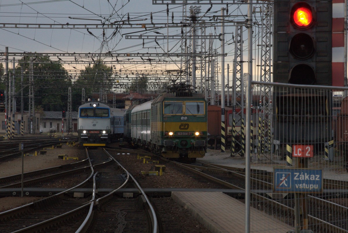 Paralleleinfahrt in Hradec Kralov, 168 084 - 7  stellt den OS nach Kolin bereit, 750 701 - 1 fährt aus Trutnov / Jaromer kommend  ein. Wegen des morgigen Tages der Eisenbahn ist das Bahnsteigende abgesperrt.Das Tele kommt an seine Grenzen.
25.09.2015 18:02 Uhr. 