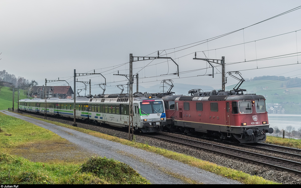 Parallelfahrt von einem Güterzug mit 2x Re 10/10, angeführt von Re 4/4 II 11326, und einem Voralpen-Express mit RBDe 561 084 am 26. November 2016 bei Immensee.
