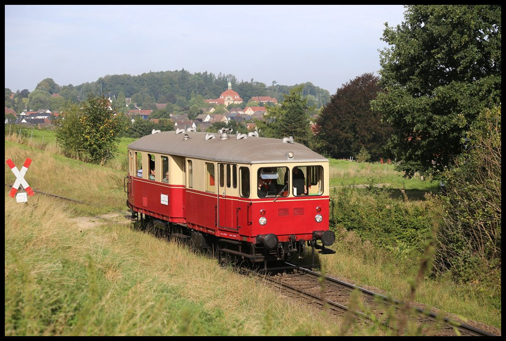 Personenverkehr auf der sogenannten Hüttenbahn von Hasbergen nach Georgsmarienhütte! Das gab es am  7.9.2024 in Form des VT 03 von Eisenbahn Tradition. Dieser brachte Besucher aus Lengerich über die Hüttenbahnstrecke zu einer Besichtigung im Stahlwerk Georgsmarienhütte. Hier erreicht der Triebwagen vor der Kulisse von Holzhausen mit der dortigen Klosterkirche um 10.43 Uhr die Einfahrt zum Werksbahnhof in Georgsmarienhütte.