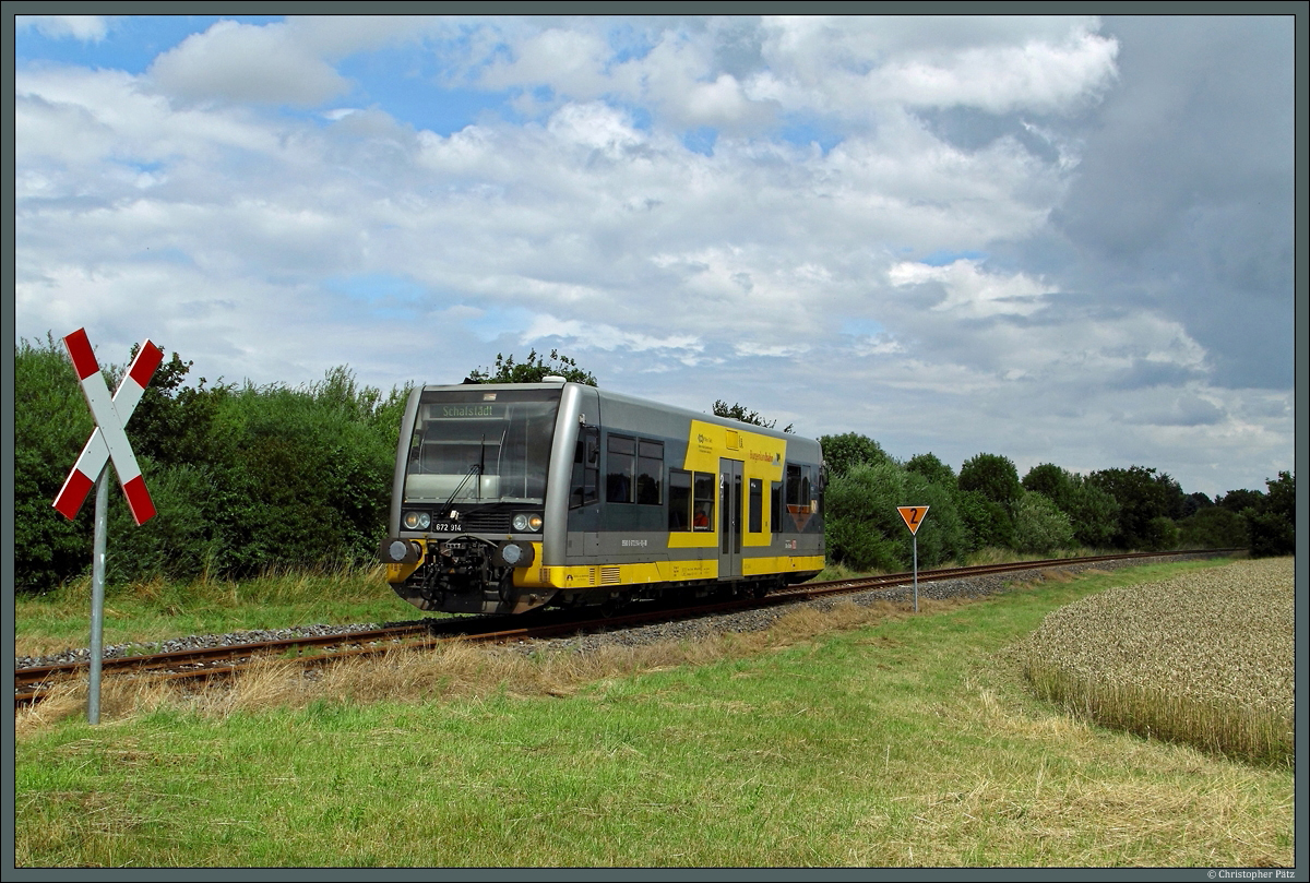 Pfeifend nähert sich 672 904 einem kleinen Feldweg bei Groß Gräfendorf, der hier die Gleise kreuzt. In wenigen Minuten erreicht RB 34918 den Endpunkt Schafstädt. (14.07.2014)