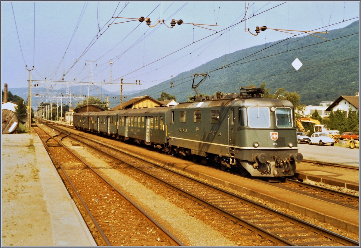 Pieterlen, eine Landstation am Jura Südfuss im Sommer 1984: Während einige Schnellzüge Richtung Delémont mit Re 4/4 I verkehren, werden die stündlichen Regionalzüge Biel/Bienne - Olten in der Regel von SBB Re 4/4 II befördert. Das Bild zeigt die SBB Re 4/4 II 11156 bei der Ankunft mit dem Regionalzug 5833. 

12. Juli 1984