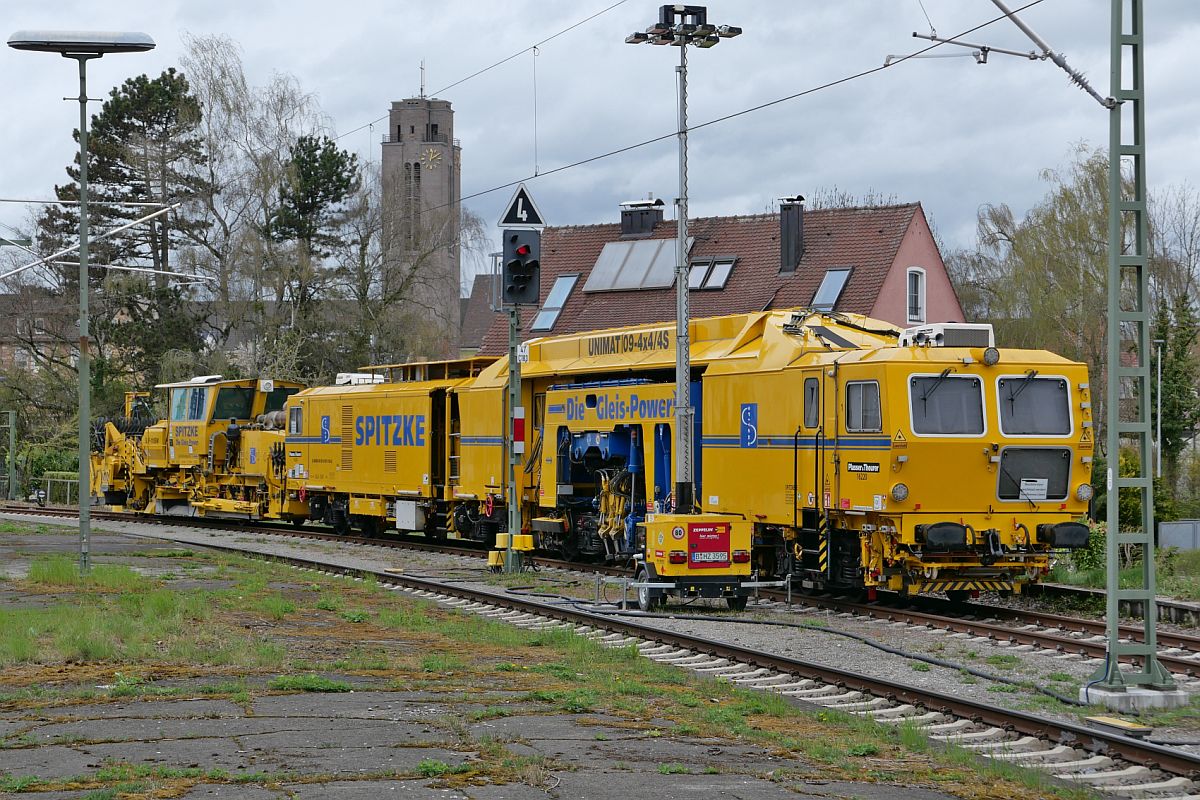 Plasser & Theurer Stopfmaschine Unimat 09-4x4/4S und Schotterprofiliermaschine SSP 110 SW von SPITZKE am 08.04.2022 in Friedrichshafen Hafen. Standort am Ende des Bahnsteiges, vor dem runden, rot umrandeten gelben Schild mit dem schwarzen Männchen