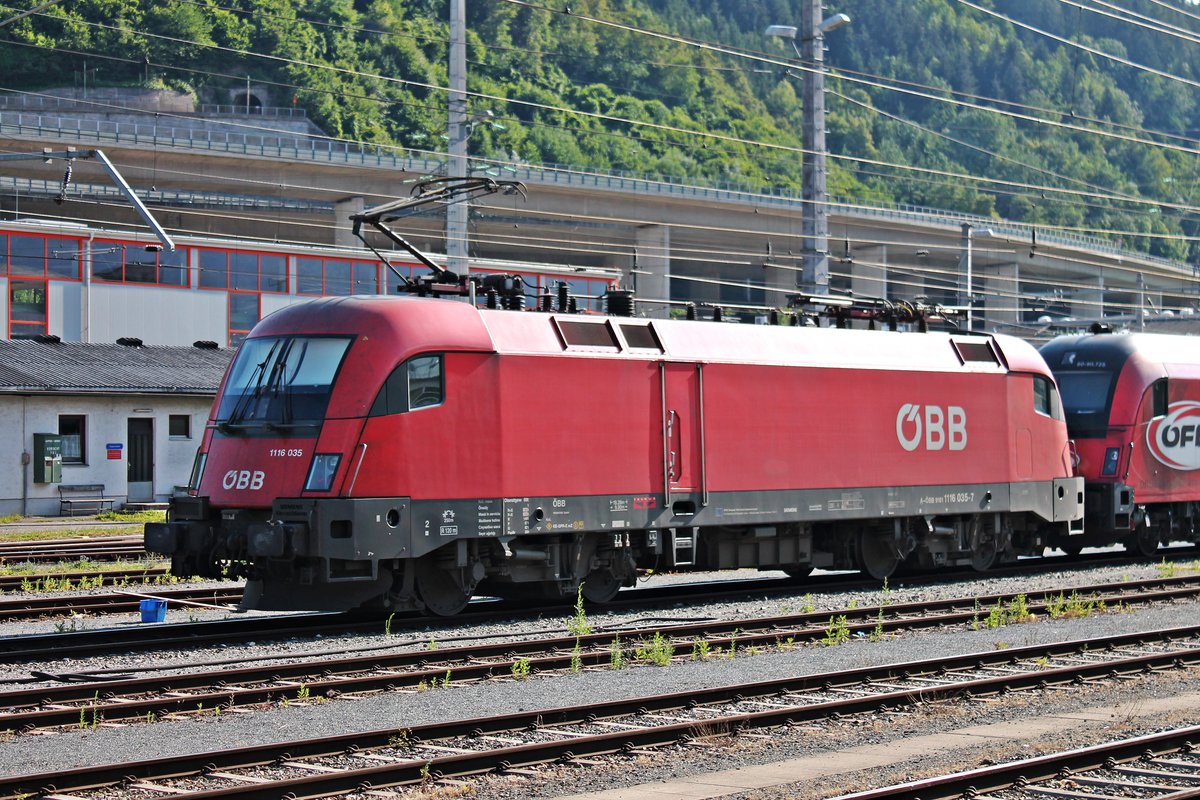 Portrait von 1116 035 am 01.07.2018, als diese mit der ÖFB-RailJet Garnitur und der 1116 200 im Abstellbereich des Innbrucker Westbahnhof abgestellt stand. Das besondere an der 1116 035 ist, dass sie einer der Loks ist die ein Osteuropa-Länderpaket (A/D/H/RO/BG/HR) umgebaut worden ist, was auch am dritten Stromabnehmer zu erkennen ist.