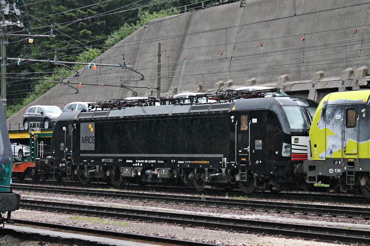 Portrait von MRCE/TXL X4 E-668 (193 668-1), als diese am Abend des 05.07.2018 zusammen mit ATLU/TXL 193 554  TXLEITWOLF  und einem KLV nach Verona Q. E. bei einem Regenschauer im Grenzbahnhof  Brennero stand.