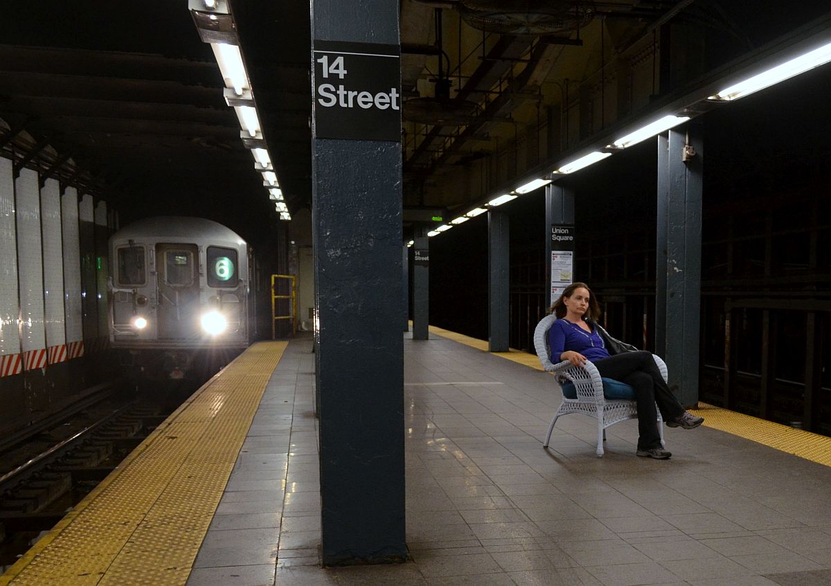 Praktisch: ungerührt nutzt diese Frau ihre Neuerwerbung(?)gleich mal als Sitzgelegenheit auf dem brütend heißen Bahnsteig der New Yorker Subway-Station  14th Street . 20.6.2014