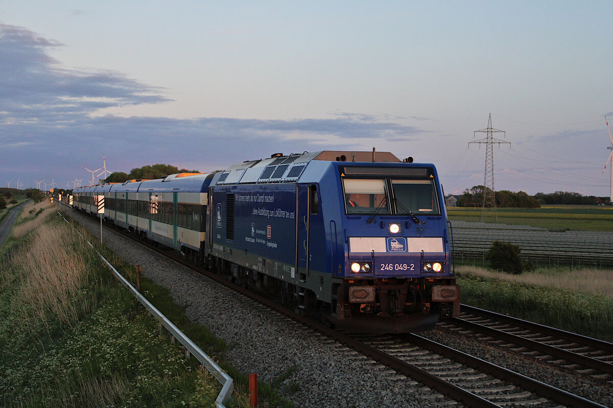 PRESS 246 049-2 zieht am Abend im letzten Licht einen RE6 nach Westerland(Sylt) und erreicht hier gerade den Hindenburgdamm. (30.05.2022)