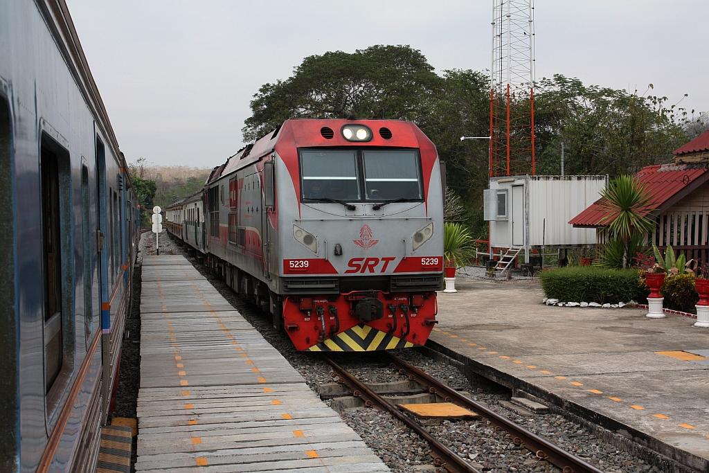 QSY 5239 (Co'Co', de, CRRC Qishuyan, Bj.2022) fährt am 25.Februar 2026 mit dem RAP 102 (Chiang Mai - Krung Thep Aphiwat) durch die Kaeng Luang Station wo der LOC 407 (Nakhon Sawan - Chiang Mai) die Kreuzung abwartet.