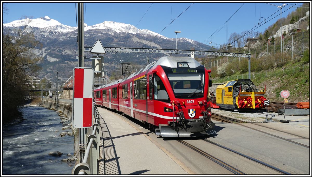 R1441 mit ABe 8/12 3507 nach Arosa neben der Schneeschleuder X rot mt 95401 beim Depot Sand in Chur. Im Hintergrund der Felsberger Calanda 2695m und der Haldensteiner Calanda 2805m. (07.04.2020)