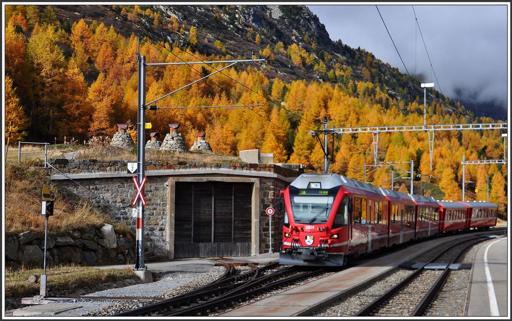 R1621 mit ABe 8/12 3509 in Bernina Suot mit dem Eingangstor zur gedeckten Drehscheibe. (08.10.2015)