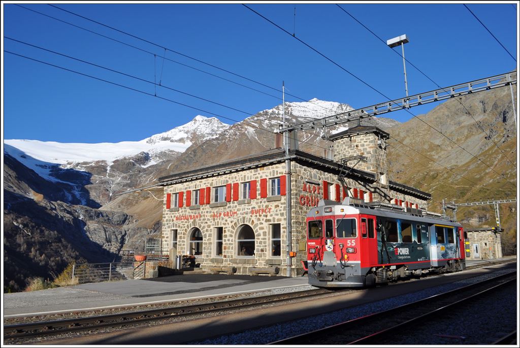 R1628 mit ABe 4/4 III 55  Diavolezza  in der Station Alp Grüm. Dahinter leuchtet der Palügletscher in der Morgensonne. (26.10.2014)