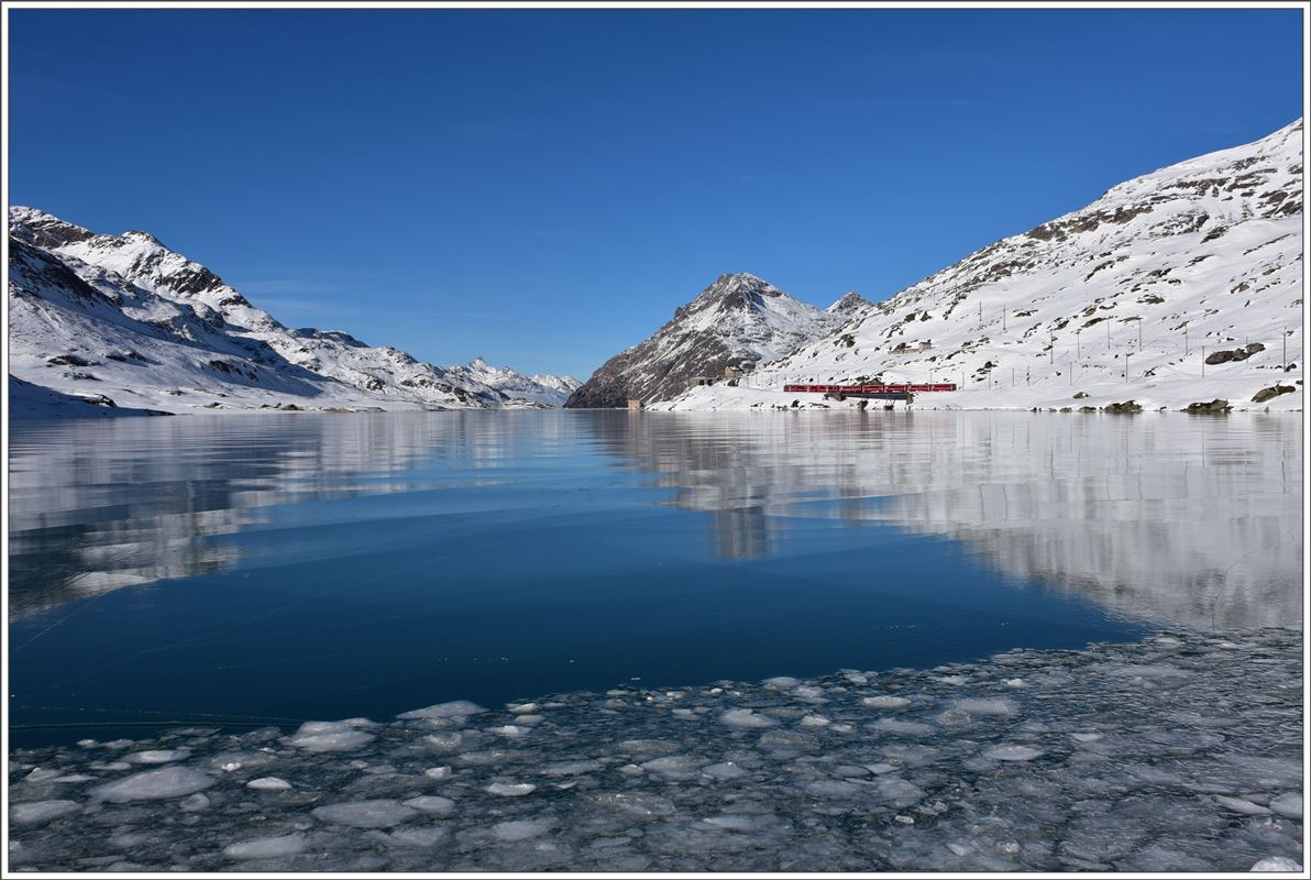 R1644 mit einem Allegra ABe 8/12 am schwarz gefrorenen Lago Bianco bei Ospizio Bernina 2253m. Im Hintergrund der Piz Ot und Piz Albris.(08.12.2016)