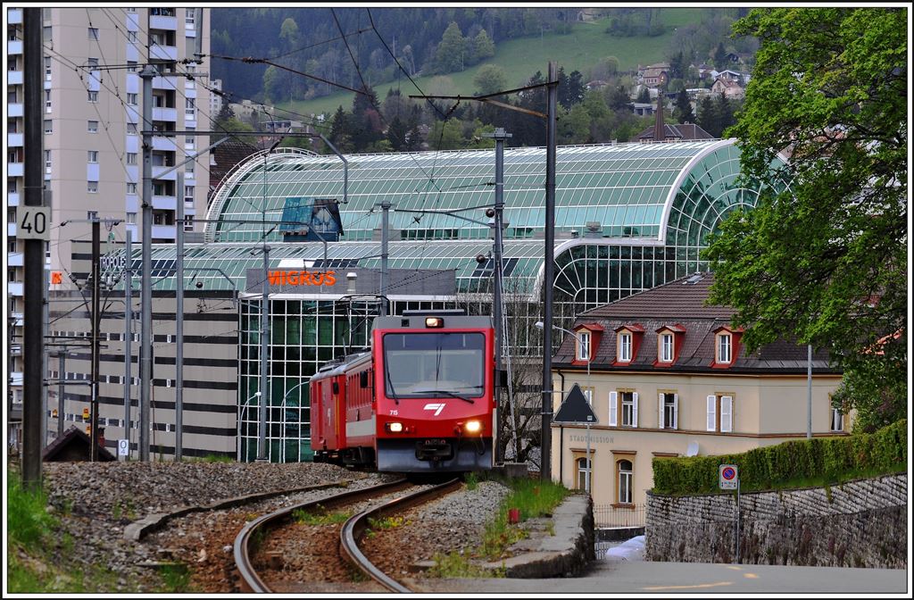 R249 mit ABt 715 an der Spitze verlässt den Bahnhof La Chaux-de-Fonds in einer kräftigen Steigung entlang der Rue de la Tranchée. (12.05.2014)