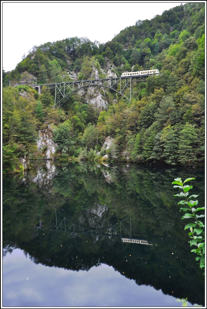 R320 mit ABe 4/6 53 auf dem Ruinacci Viadukt bei Camedo spiegelt sich im Palagnedra Stausee.(03.09.2014)