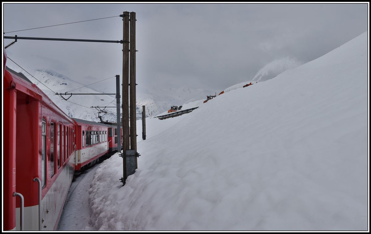 R823 mit Deh 4/4 21 nach Andermatt kurz vor Nätschen. Drei Schneefräsen sind damit beschäftigt die Passstrasse vom meterhohen Schnee zu befreien. (10.04.2019)