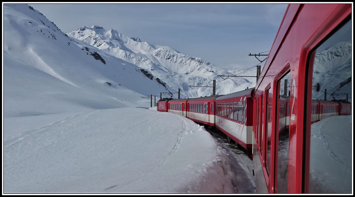 R923 mit HGe 4/4 107 oberhalb Nätschen. Im Hintergrund sieht man den Gemsstock, wo immer noch Ski gefahren wird. (16.04.2019)