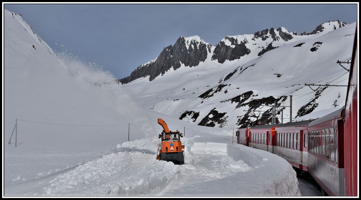 R923 mit HGe 4/4 107 überholt kurz vor der Oberalppasshöhe eine Schneefräse des Bündner Strassenbauamtes. Während die Urner die Passhöhe bereits erreicht haben, sind die Bündner noch mit der Räumung der Passstrasse beschäftigt. (16.04.2019)
