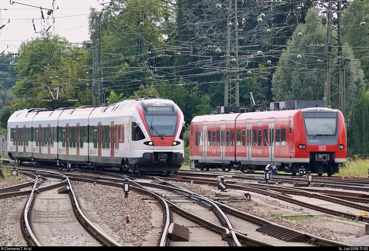 RABe 521 009 (Stadler FLIRT) der Regio-S-Bahn Basel (SBB) als SBB87697  Seehas  von Engen nach Konstanz fährt am abgestellten 426 014-7 von DB Regio Baden-Württemberg vorbei und erreicht damit den Bahnhof Singen(Hohentwiel) auf Gleis 2.
Aufgenommen am Ende des Bahnsteigs 4/5.
[14.7.2018 | 17:02 Uhr]