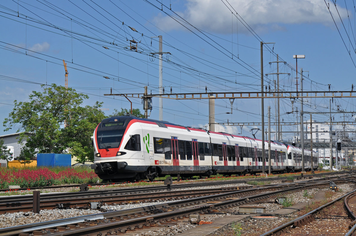 RABe 521 017, auf der S1 verlässt den Bahnhof Pratteln. Das abzweigende Gleis führt auf eine Strasse und in ein Industriegebiet, vom wo aus auch diese Aufnahme am 28.05.2016 entstand.