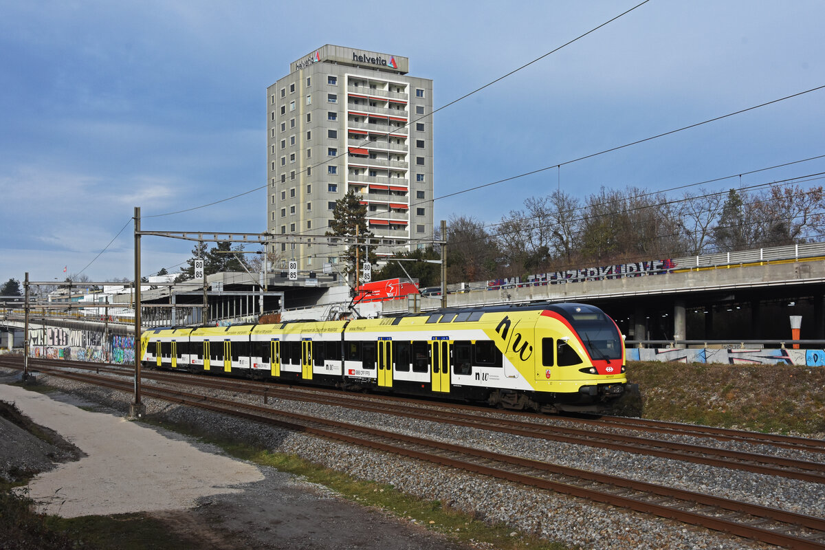 RABe 521 017 mit der Werbung für die Fachhochschule Muttenz, auf der S1, fährt Richtung Bahnhof Muttenz. Die Aufnahme stammt vom 23.12.2021.