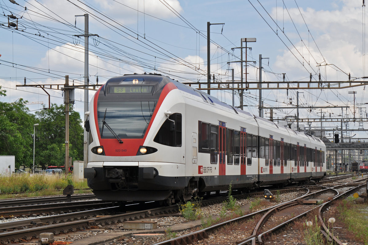 RABe 523 040, auf der S3, verlässt den Bahnhof Pratteln. Das abzweigende Gleis führt auf eine Strasse und in ein Industriegebiet, von wo aus auch diese Aufnahme am 28.06.2016 entstand. 