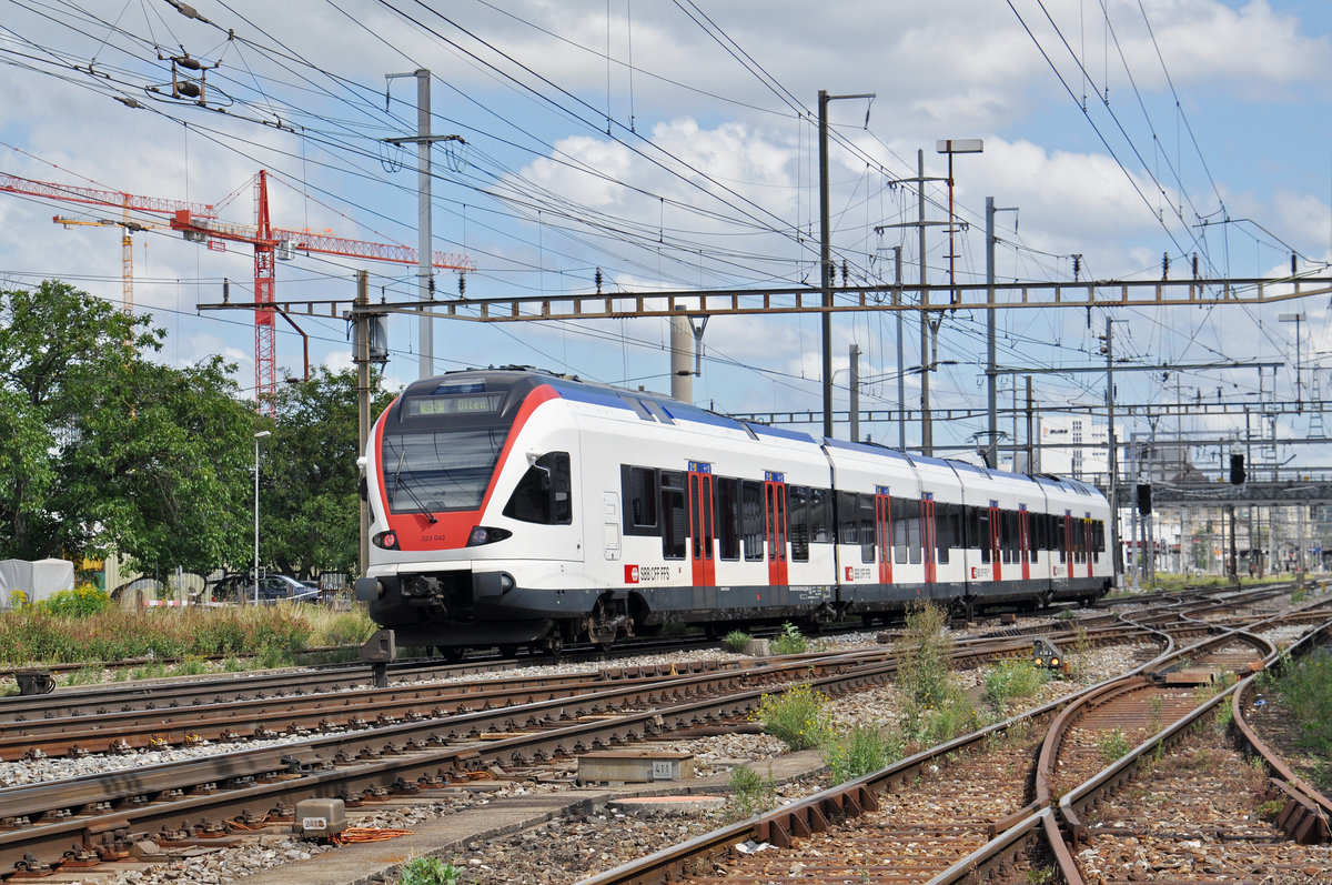 RABe 523 042, auf der S3, verlässt den Bahnhof Pratteln. Das abzweigende Gleis führt auf eine Strasse und in ein Industriegebiet, von wo aus auch diese Aufnahme am 21.08.2016 entstand.