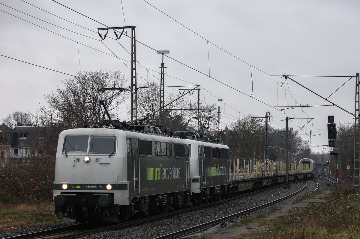 RADVE 111 082 und 111 029 ziehen 6 Rungenwagen, 2 Kuppelwagen und einen Schutz-/Bremswagen nach Rheydt Gbf durch Rheydt Hbf. 