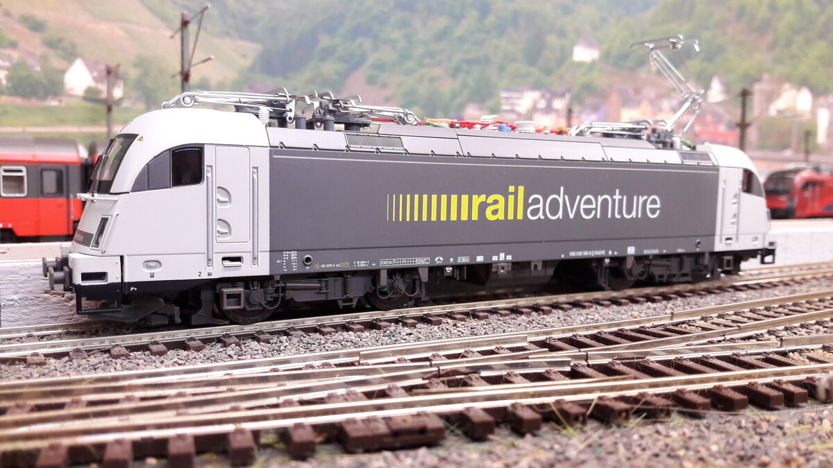 RailAdventure, ist ein Unternehmen mit Sitz in München, welches sich aus Spezialtransporte und Überführungen spezialisiert hat, Meist werden immer sogenannte Schutz und Begleitwagen bei den Transporten eingesetzt. Hier eine Siemens ES64U4 BR 183 500 in Harrstadt Hauptbahnhof. Das Modell ist von Piko 59918, DC digital