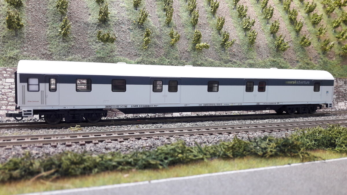 RailAdventure, ist ein Unternehmen mit Sitz in München, welches sich aus Spezialtransporte und Überführungen spezialisiert hat, Meist werden immer sogenannte Schutz und Begleitwagen bei den Transporten eingesetzt. Hier ein sogenannter Begleitwagen, ein ehemaliger Gepäckwagen Dmz , grauer Streifen ganz oben. Der Wagen ist von Tillig 74877