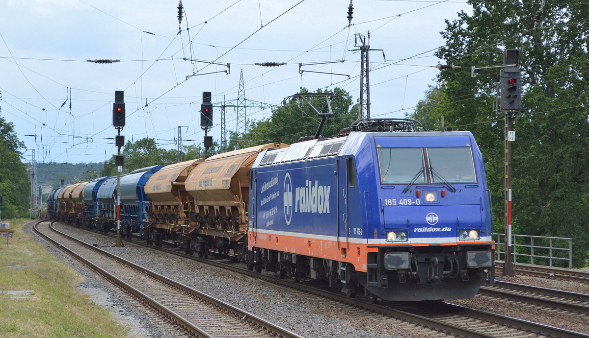 Raildox GmbH & Co. KG mit  185 409-0  [NVR-Nummer: 91 80 6185 409-0 D-RDX] und einem Güterzug Schüttgutwagen mit Schwenkdach (skw PIESTERITZ) am 06.07.19 Saarmund Bahnhof.