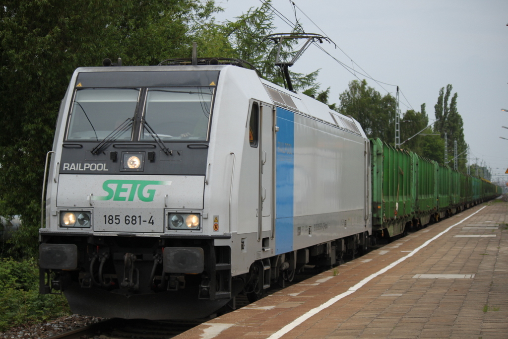 Railpool 185 681-4 SETG  mit Holzzug von Rostock-Bramow nach Stendal-Niedergrne bei der Durchfahrt im Haltepunkt Rostock-Holbeinplatz.(28.05.2015)