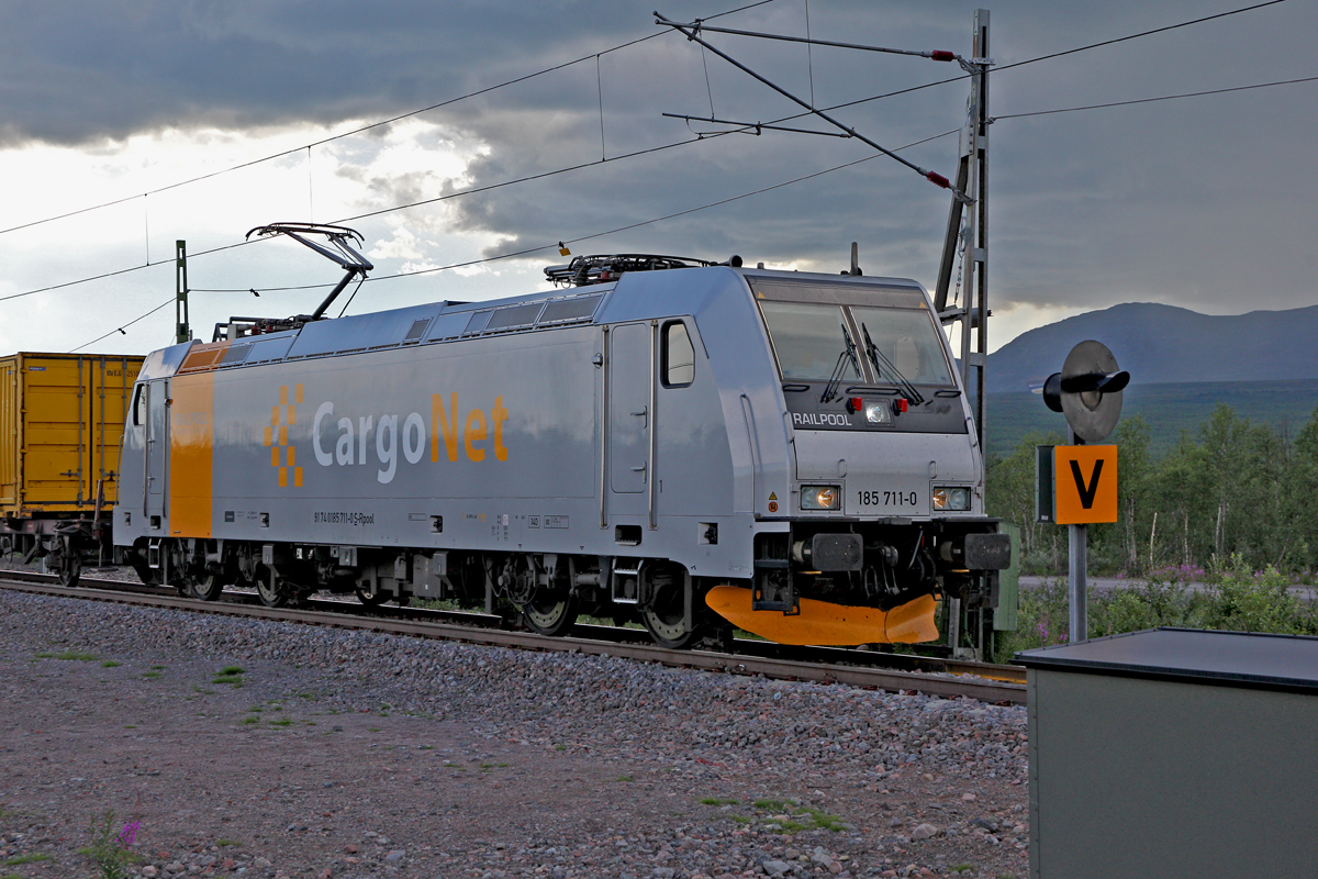 Railpool 185 711-0 kommt bei herannahenden Gewitter mit einem Containerzug bei Rautas/Schweden vorbei.Bild vom 20.7.2014