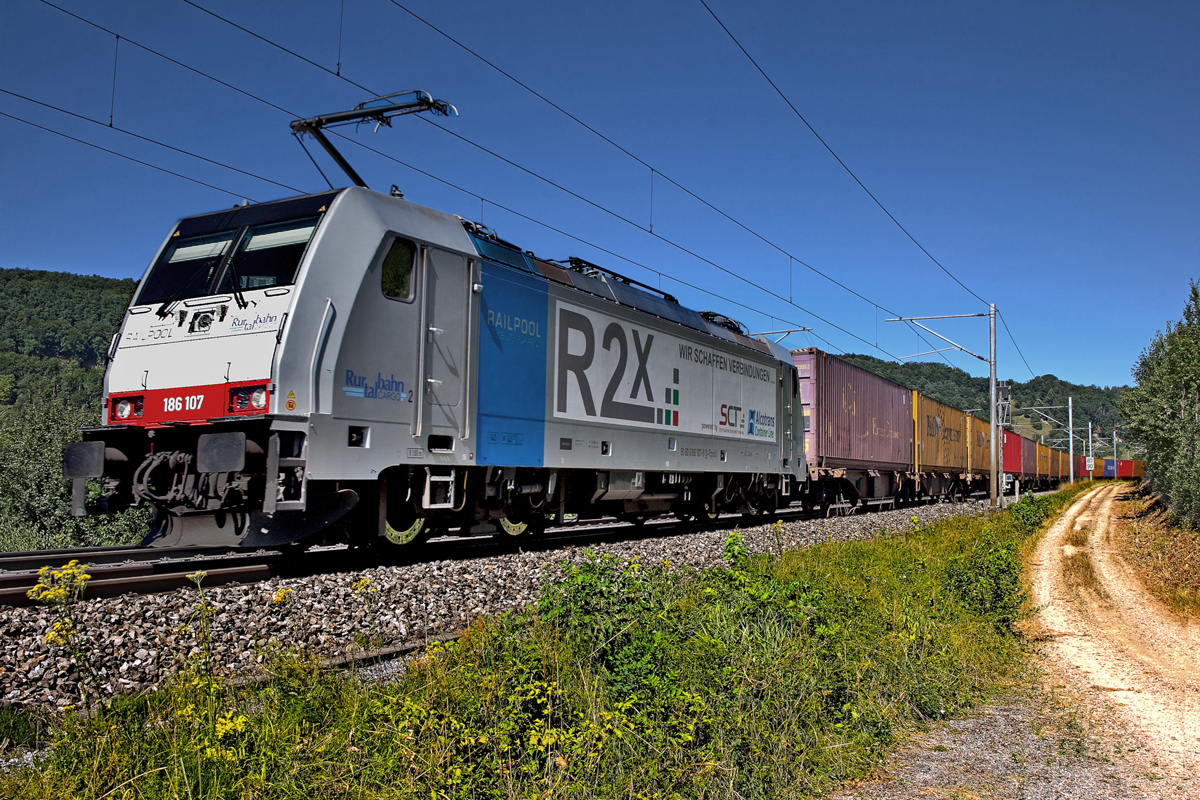 Railpool 186 107 donnert bei Hornussen mit einem UKV Zug den Bözberg hinunter.Bild vom 10.7.2015