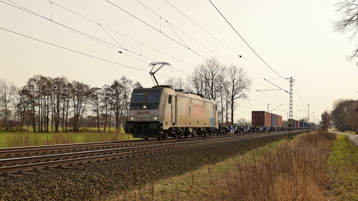 Railpool E 186 276, vermietet an Lotos Kolej, mit Containerzug in Richtung Bremen. Die gelblich Färbung der Schleierbewölkung wurde durch Saharastaub verursacht, der mit Südwestwind bis ins westliche Niedersachsen gelangte (Diepholz, 22.02.2021).
