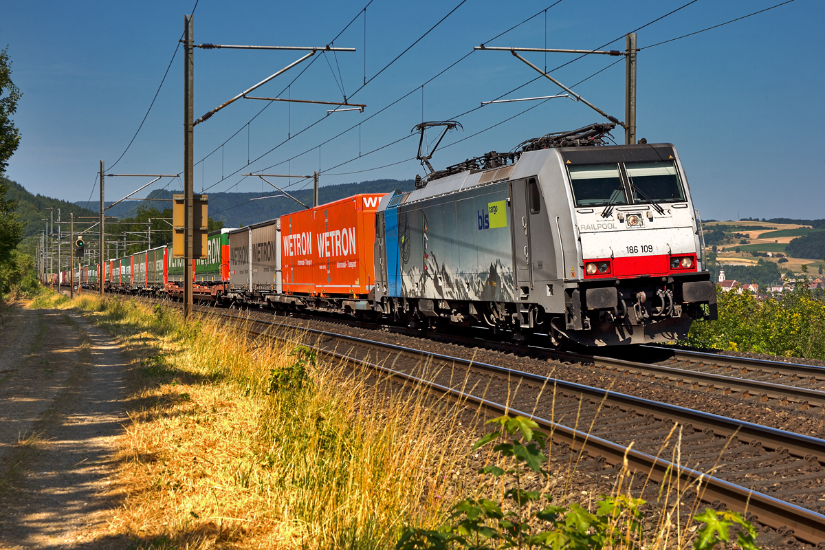 Railpool Maschine 186 109 donnert in Frick bei grosser Trockenheit mit einem UKV Zug vorbei.Bild vom 16.7.2015