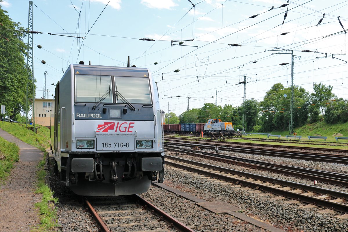 Railpool/IGE 185 716-8 trifft auf SGL Voith Gravita V170.15 (261 309-9) am 07.06.19 in Hanau Hbf Südseite von einen Gehweg fotografiert der öffentlich zugänglich ist 