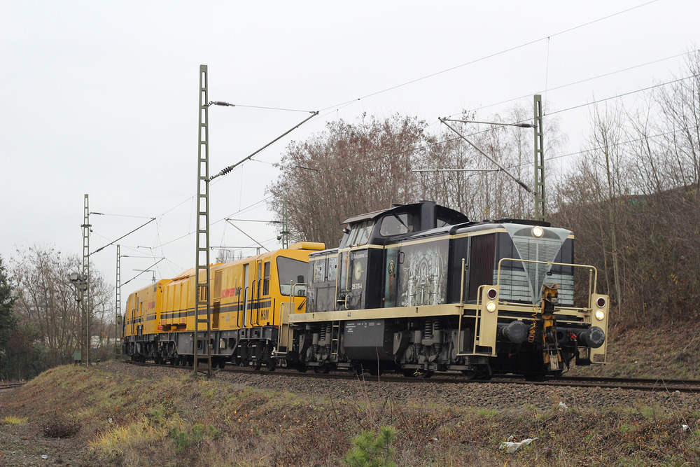 Railsystems RP 295 076 mit einem Gleisbaufahrzeug der Firma Schweerbau, fotografiert am 15. Dezember 2016 in Köln.
Die Aufnahme entstand von einer öffentlichen Straße aus.
