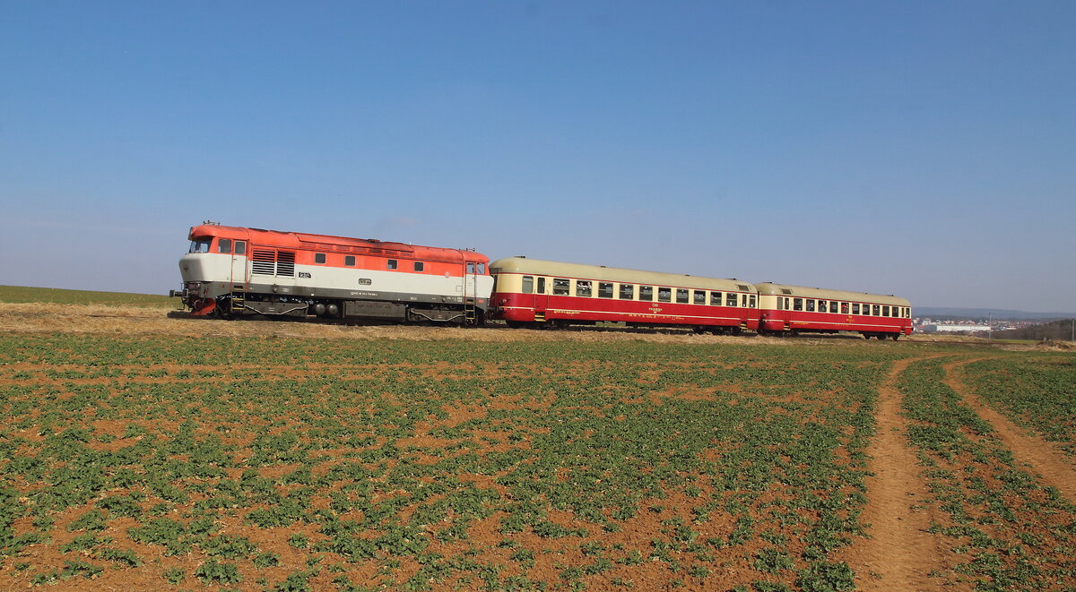 Rakovnik Express von Prag auf dem Weg nach Kralovice. Vor wenigen Minuten hat der Zug Rakovnik verlassen und schlängelt sich durch die Felder dem Ziel mit 749 006 der KZC entgegen. Aufgenommen am 26.03.2022
